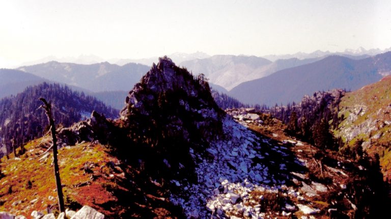 The rocky west horn of Lichtenberg Mountain stands above a ridge covered with autumn vegetation