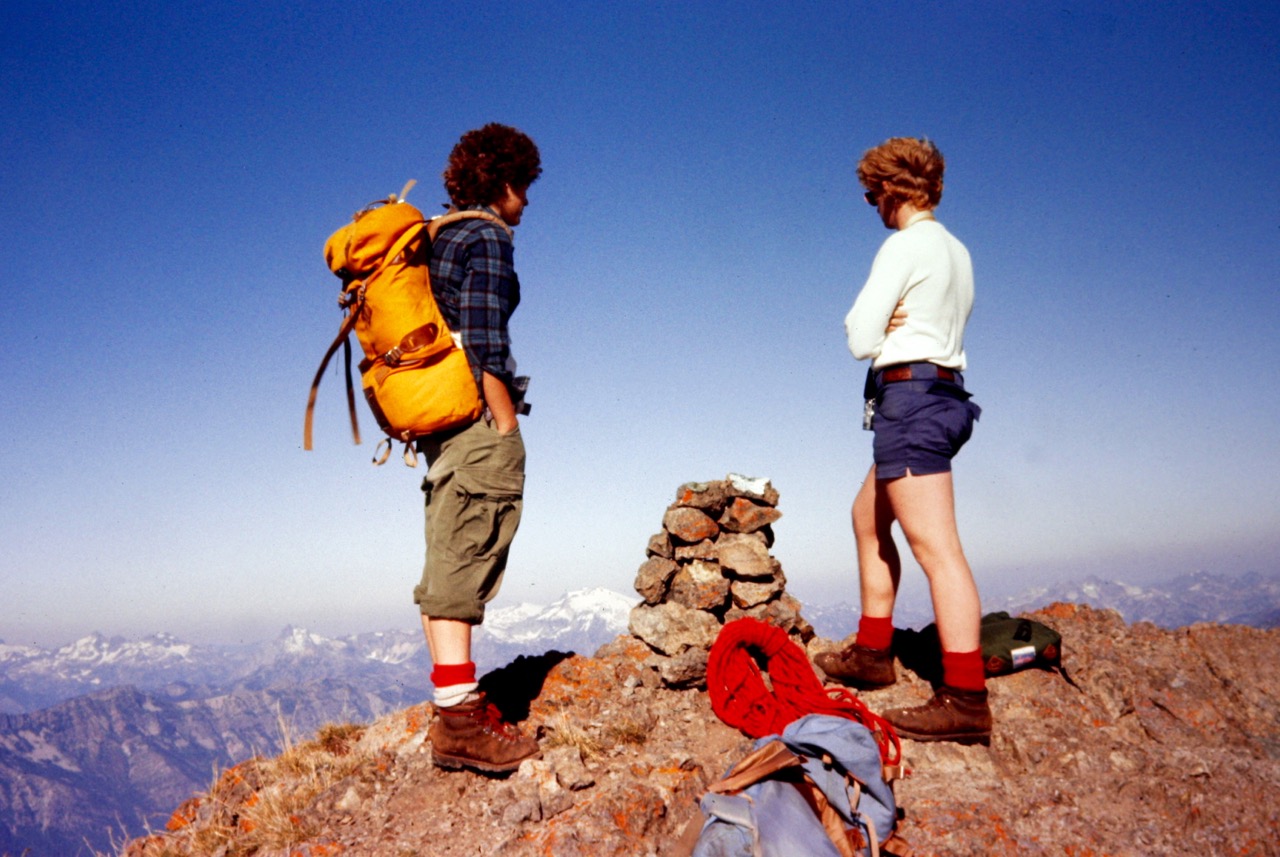 Two mountain climbers stand on the summit of South Ingalls Peak