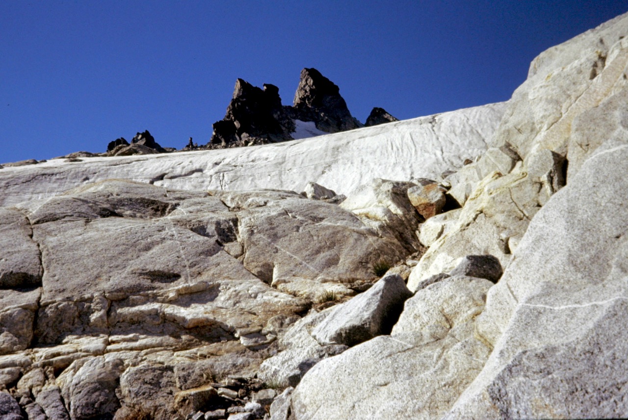looking up steep rock slabs towards the rocky summit horns of Tenpeak Mountain in the Glacier Peak Wilderness
