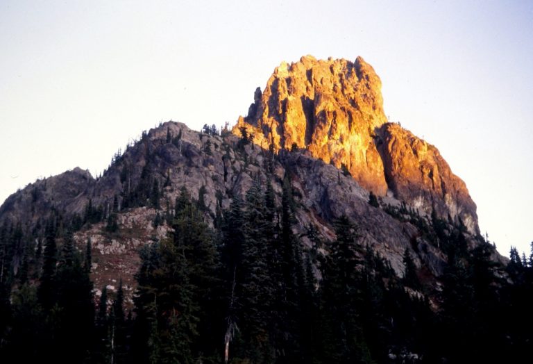 Morning alpenglow warms up the summit of Cathedral Rock in the Alpine Lakes Wilderness