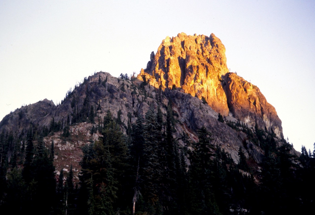 Morning alpenglow warms up the summit of Cathedral Rock in the Alpine Lakes Wilderness