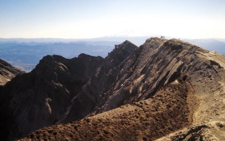 Mountain climbers stand on the barren crater rim of Mount St Helens