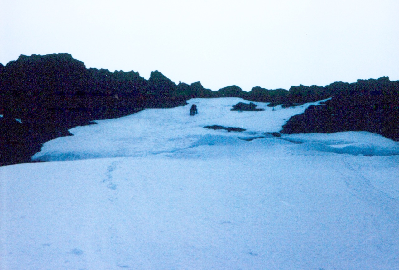 A climber ascends a steep snowfinger to summit of Whitehorse Mountains in the Cascade Range
