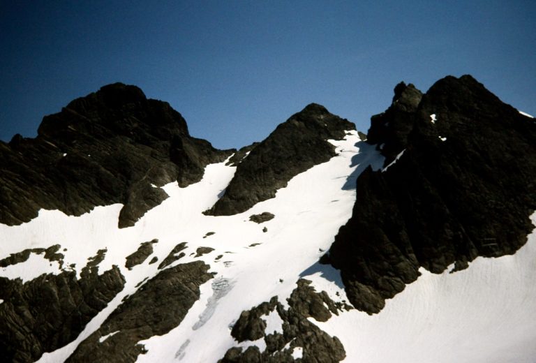 The multiple peaks of Three Fingers Mountain stand above a steep glacier