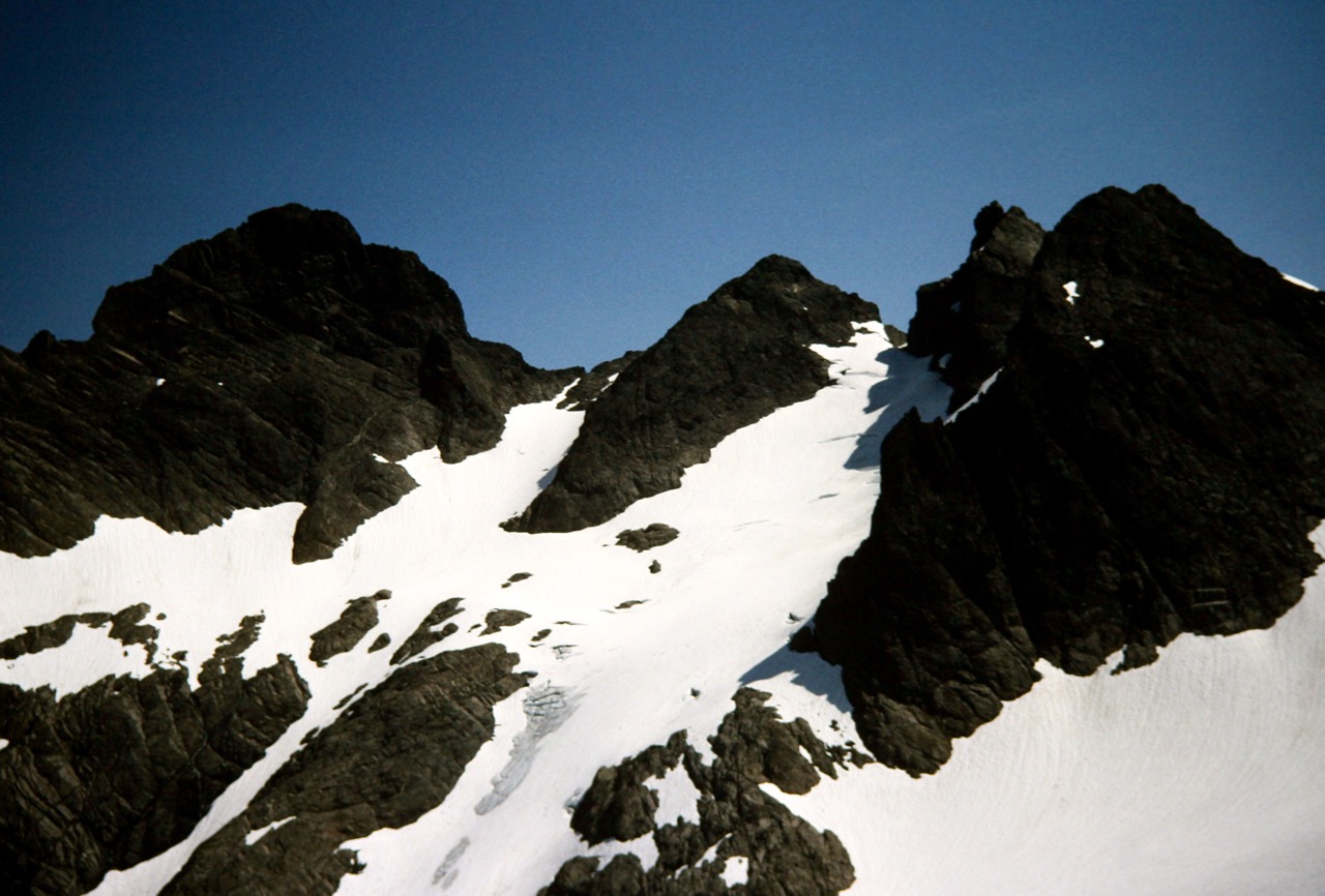 The multiple peaks of Three Fingers Mountain stand above a steep glacier