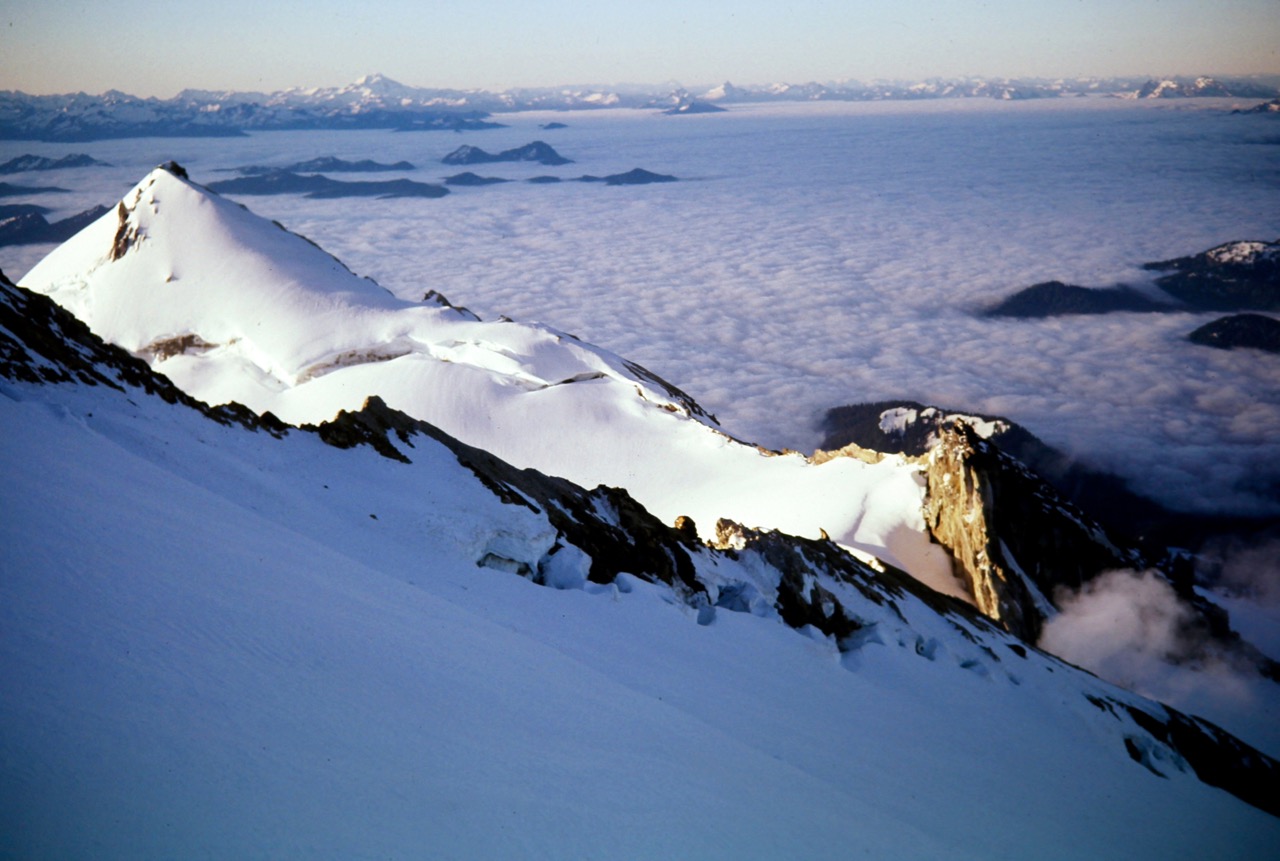 Morning sun highlights Sherman Peak as viewed from summit of Mt Baker