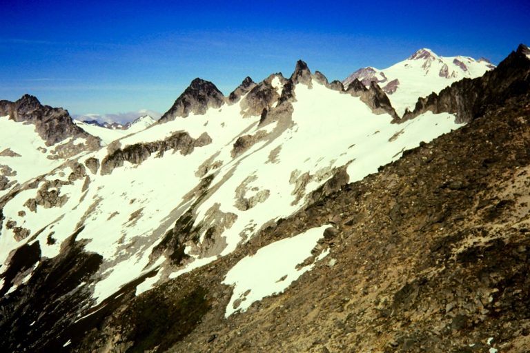 Craggy Tenpeak Mountain in the Glacier Peak Wilderness and snowy Glacier Peak rise above Thunder Basin during High Thunder Traverse in the Chiwawa Mountains and DaKobed-White Range