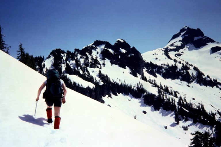 A solo climber hikes through deep snow toward Mt Chaval
