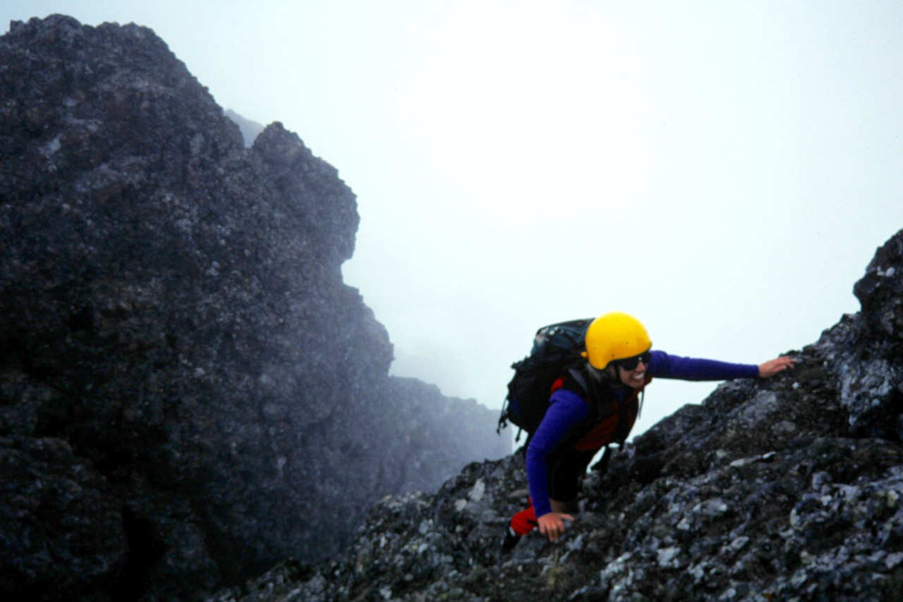 A climber scrambles up a rock cliff on Mt Stone in the Olympic Mountains