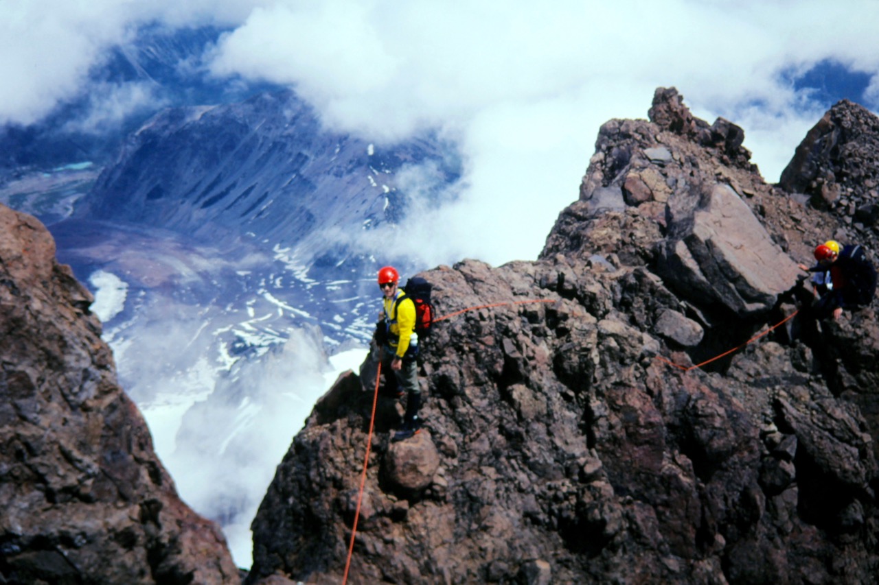 Rock climbers scramble along an exposed ridge on Little Tahoma Peak
