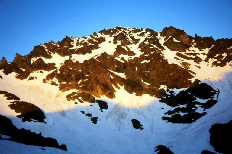 Morning sun lights up the snowy face of Mt Deception viewed from Royal Basin