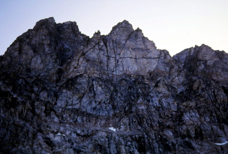 Looking up at the vertical light gray face of Mt Goode