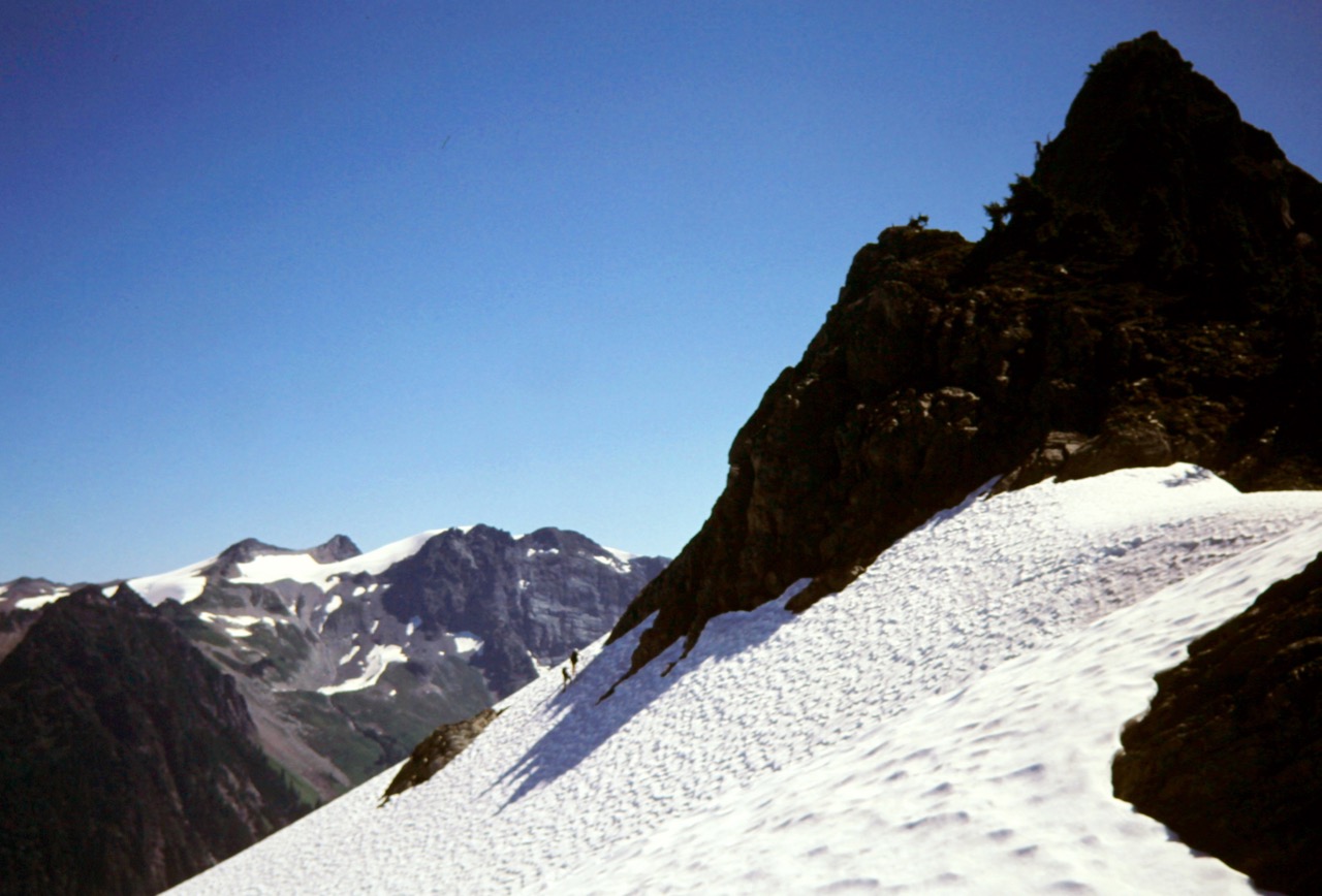 Mountain climbers cross a steep snowfield closely below Mt Watson