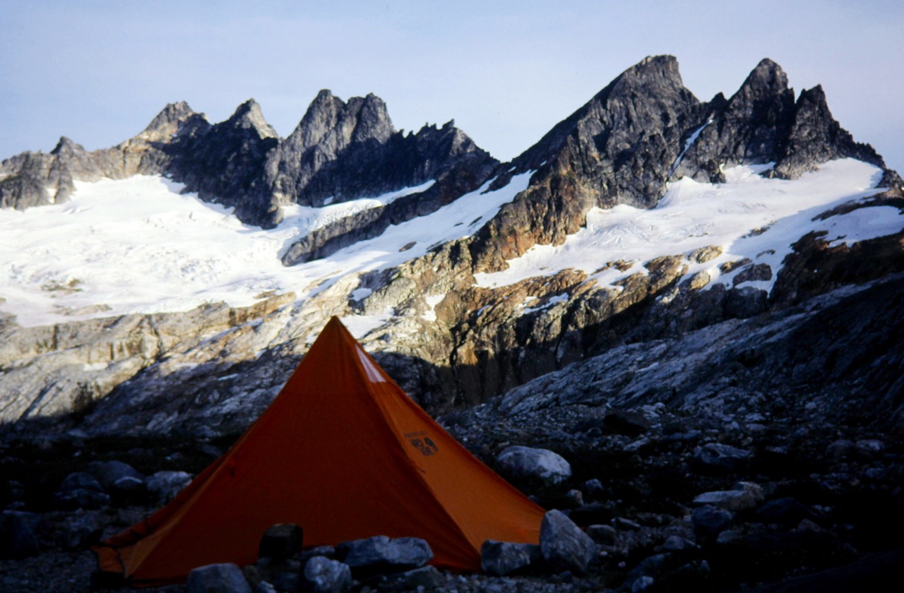 An orange tent sits on a bench below the jagged Southern Picket Range