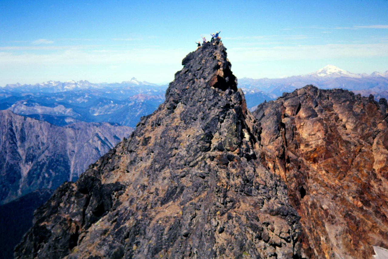 A group of mountain climbers wave from the summit of Big Chiwuakum Peak during the Deadhorse Traverse in the Alpine Lake WIlderness