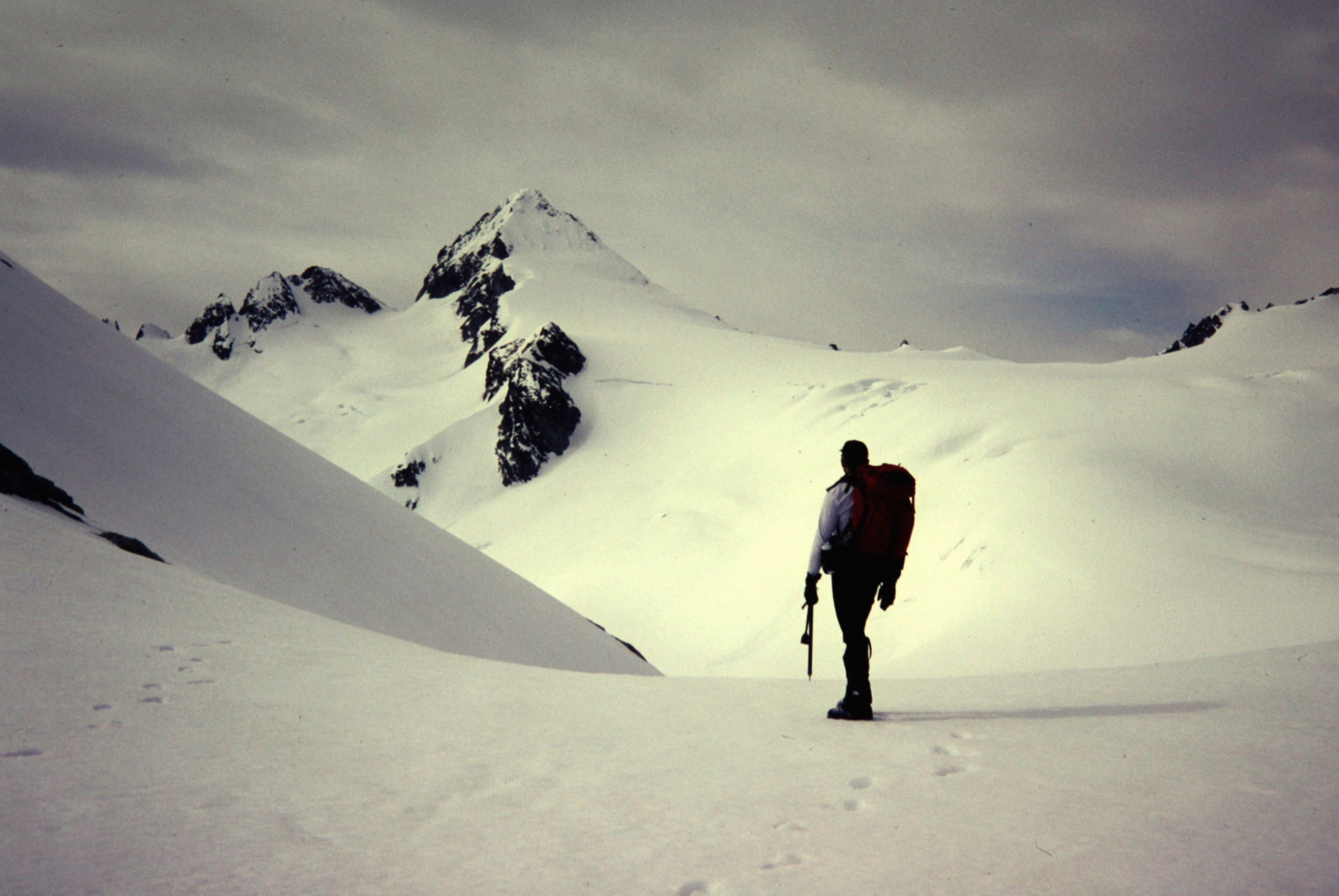 A mountain climber stands on a glacier below Snowfield Peak