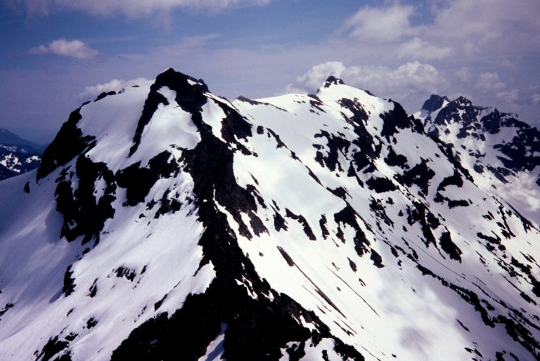 A cluster of snowy peaks in the Monte Cristo Mountains seen from Foggy Peak