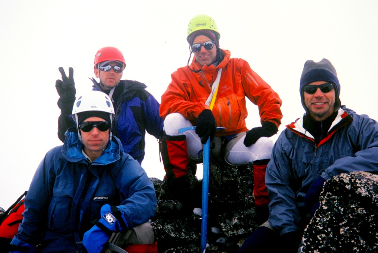 mountain climbers breaking on the summit of Tricouni Peak in the McAllister Mountains on the Inspriation Traverse
