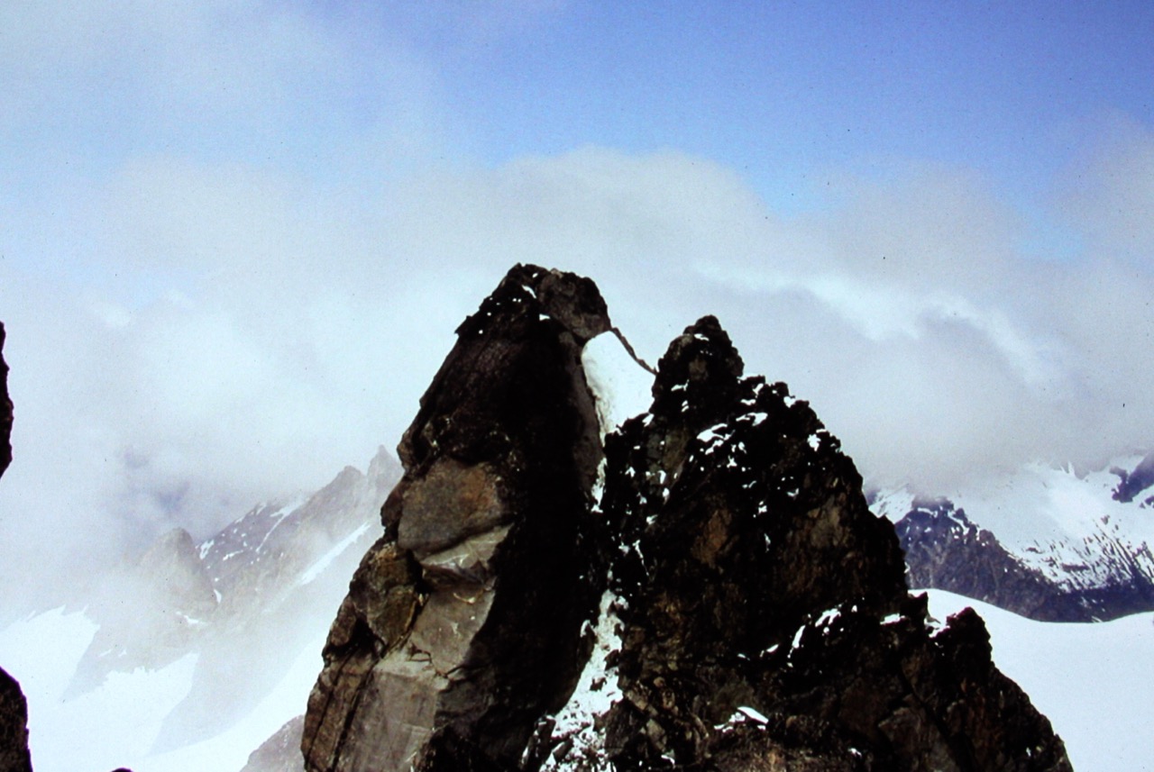 rock, horn summit of Austera Peak in the McAllister Mountains with a snow dusting and swirling clouds