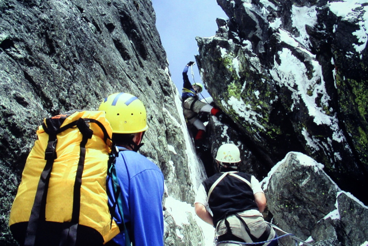 roped mountain climbers climbing the icy cover summit block on Austera Peak on the Inspiration Traverse in the North Cascades