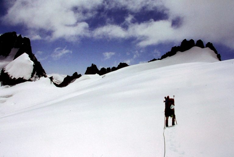 During the Inspiration Traverse, a mountain climber traverses the Klawatti Glacier below a jagged ridge crest