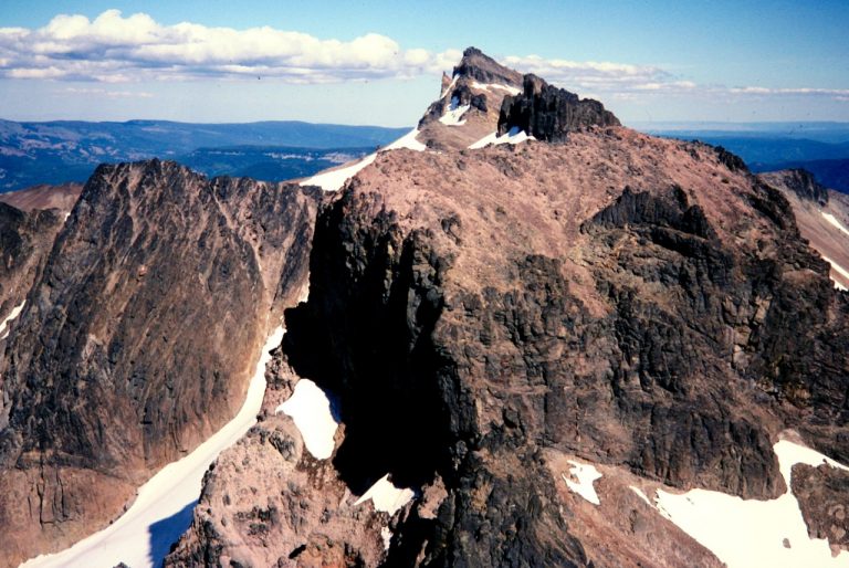 The pyramidal summit of Mt Curtis Gilbert rises above a rocky ridge in the Goat Rocks
