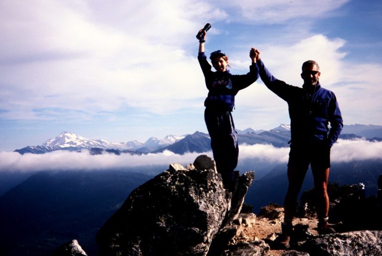 A father and daughter wave their arms on the summit of Labyrinth Mtn