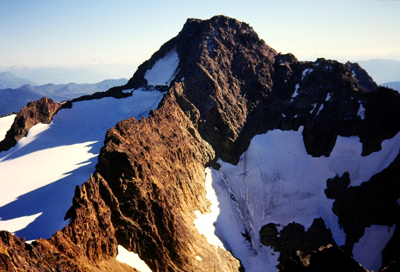 The red rock and white snow of South Twin Sister dominates the horizon from North Twin Sister