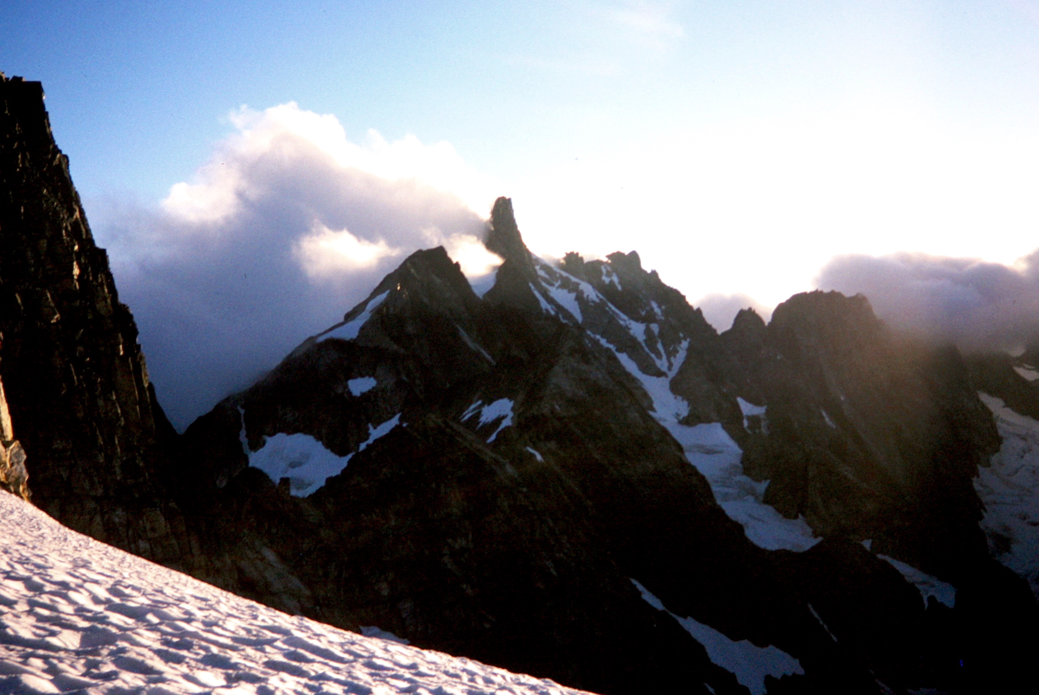 Clouds On East Mt Fury Peak with snow fields in foreground in the Northern Picket Range
