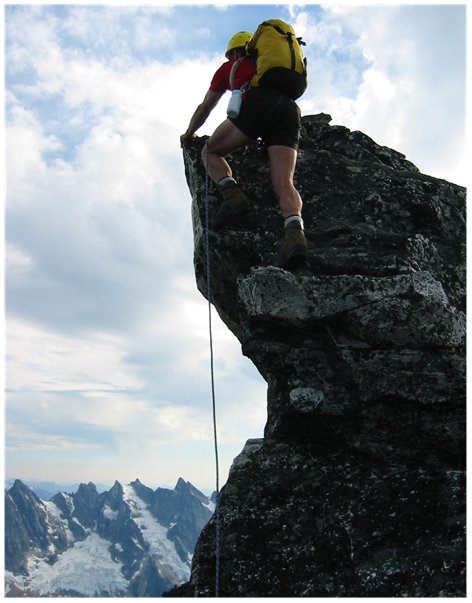 lead mountain climber roped on the summit horn of Luna Peak in the Northern Picket Range