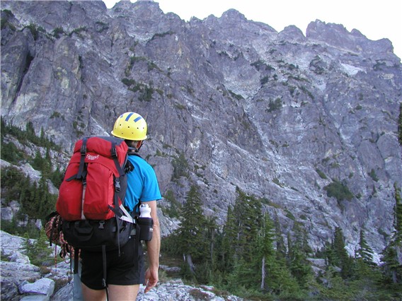 mountain climber scoping out key rock gully on the steep Southwest Face of Bears Breast Mountain in the Alpine Lakes Wilderness