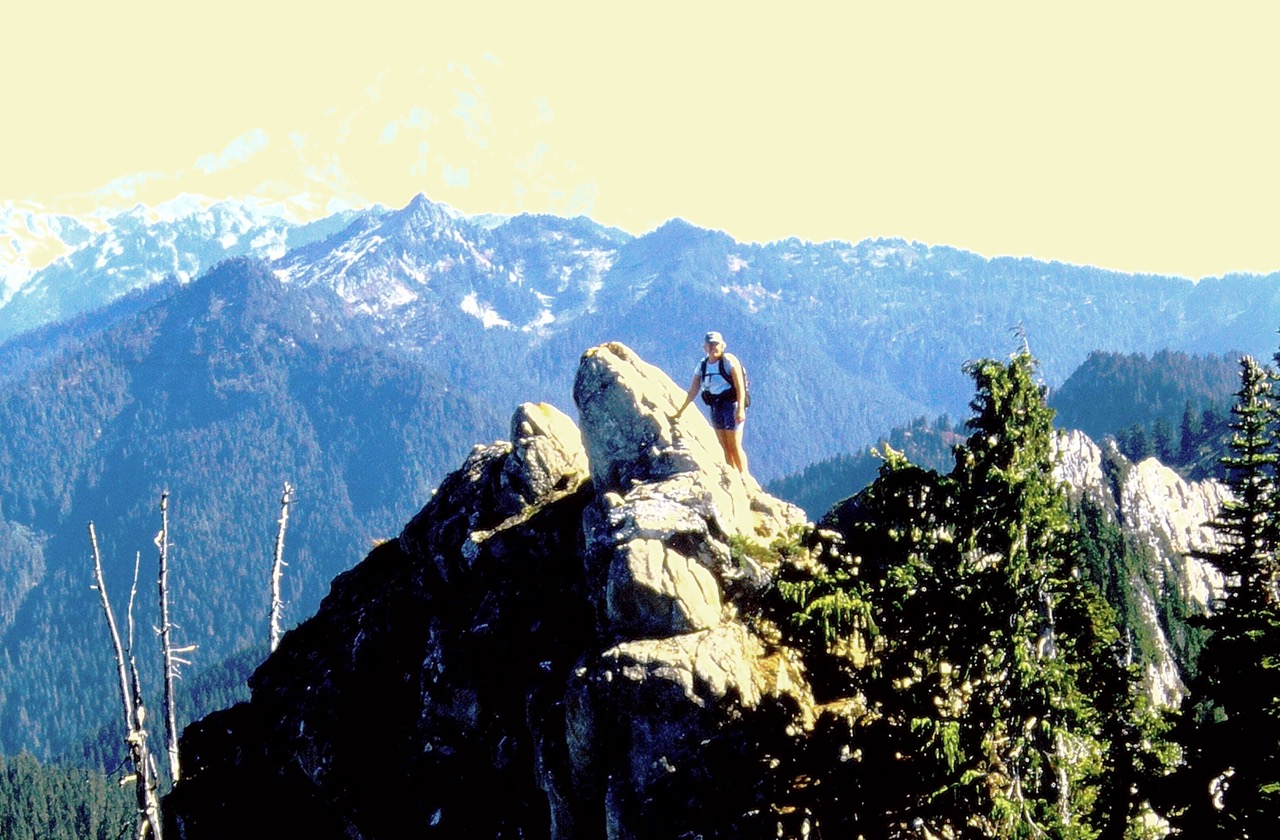 A rock climber scrambles across a knife-edge ridge crest on Circle Peak