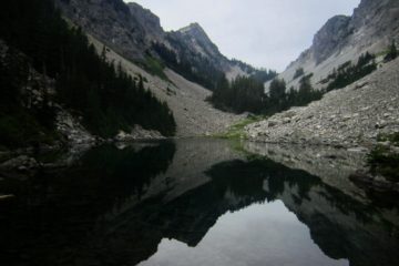 Kaleetan Peak is reflected on the glassy surface of Upper Melakwa Lake in the Snoqualmie Mountains, WA