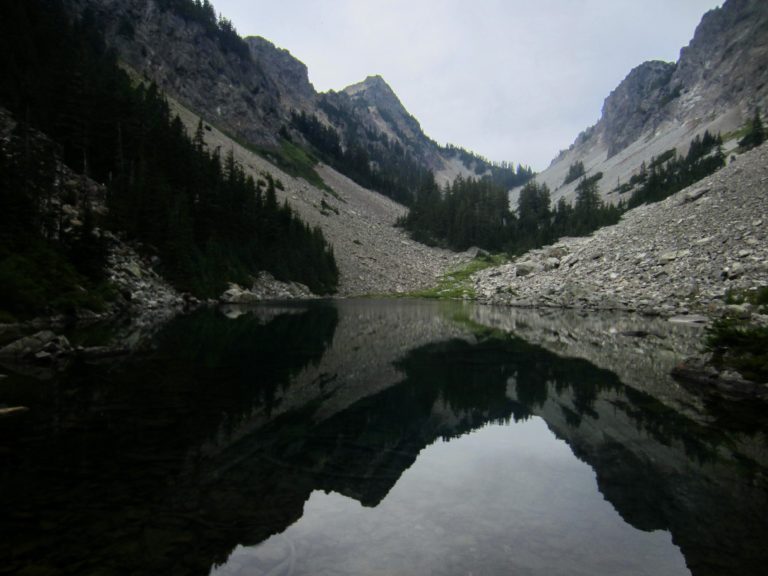 Kaleetan Peak is reflected on the glassy surface of Upper Melakwa Lake in the Snoqualmie Mountains, WA