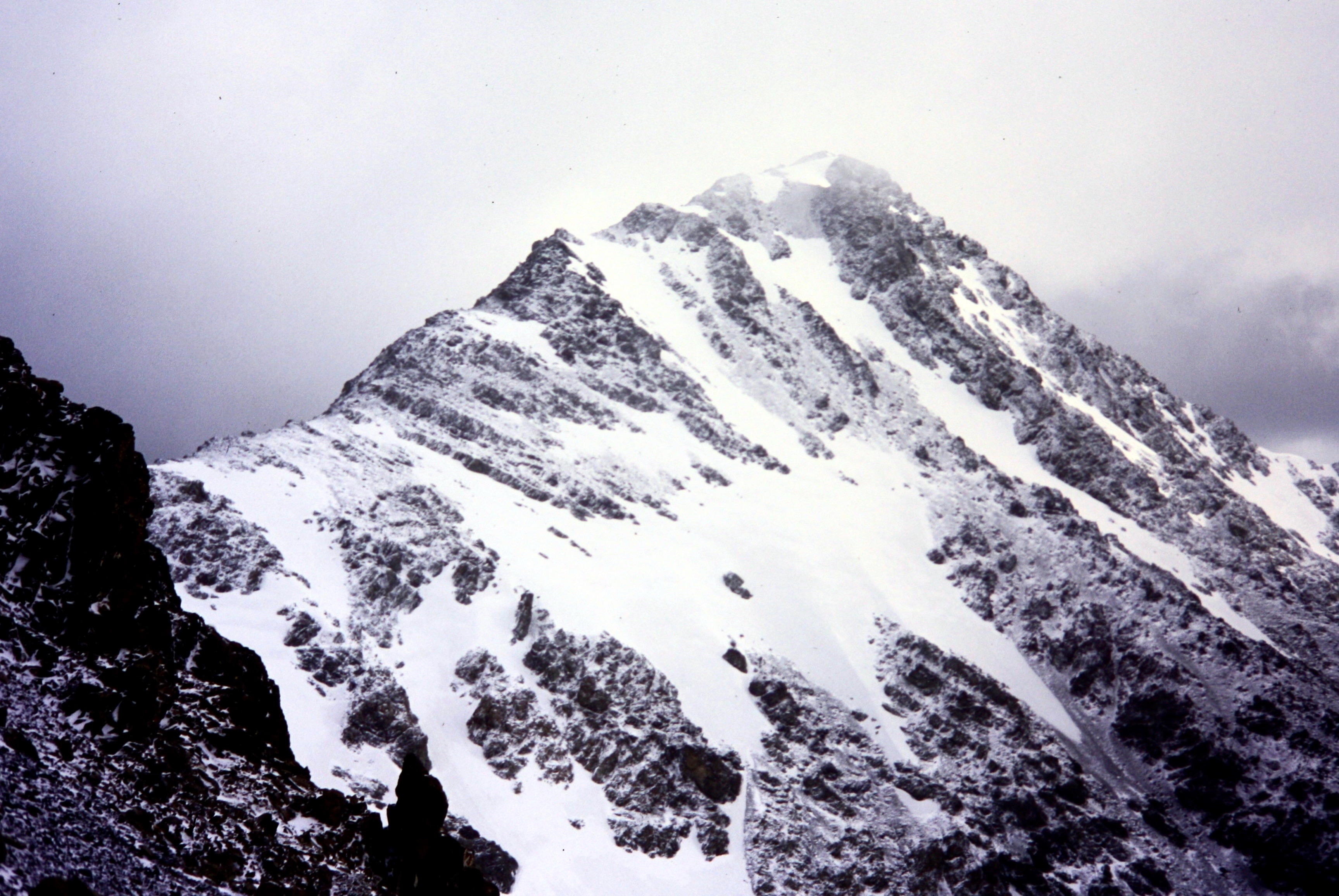 Looking along rocky ridge at snow-dusted summit of North Gardner Mountain
