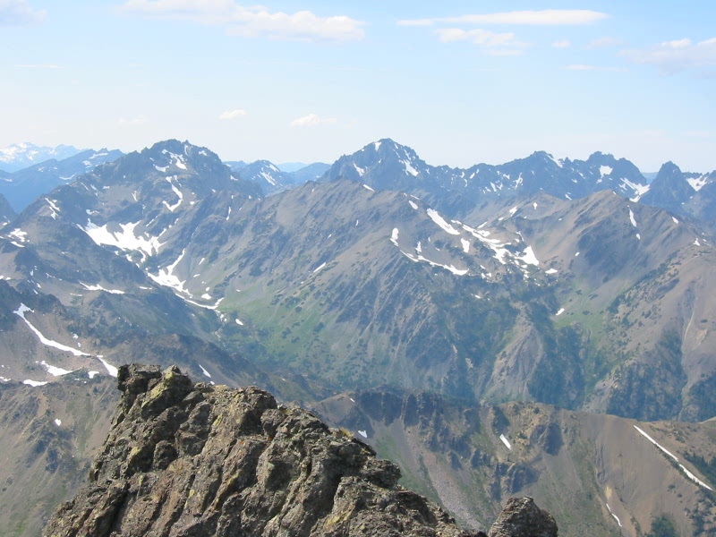 Mt Mystery, Mt Deception, and Royal Needles in the Olympic Mountains in the distance with the summit ridge of Inner Mt Constance Peak in the foreground