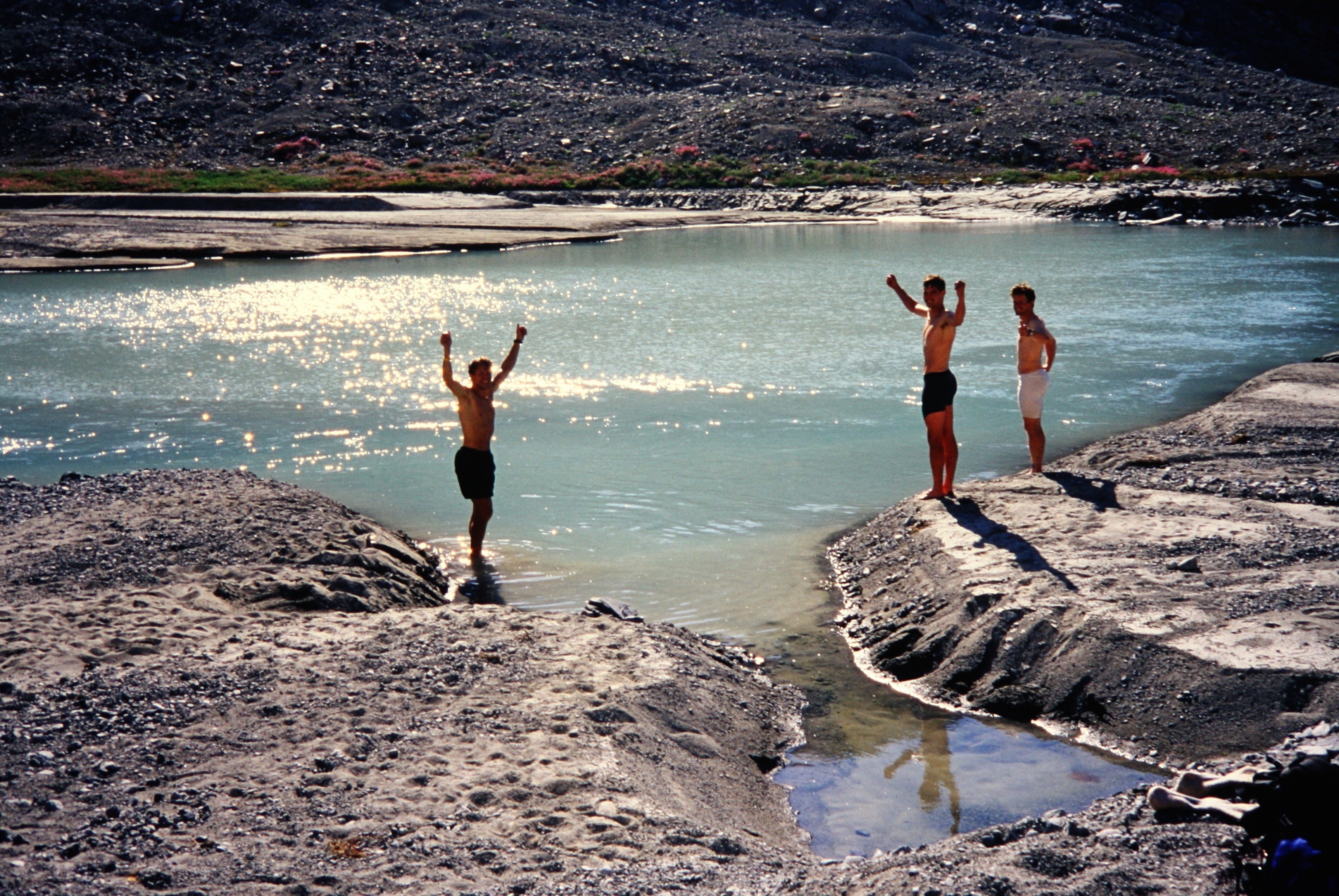 mountain climbers celebrating by swimming in Ouzel Lake with rocky shores