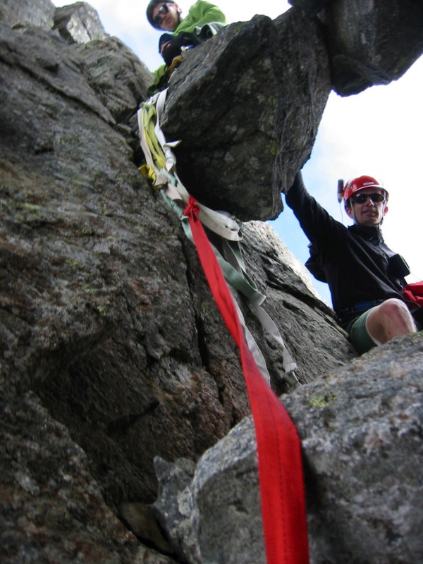 mountain climbers at the key chockstone covered with repel runners 
