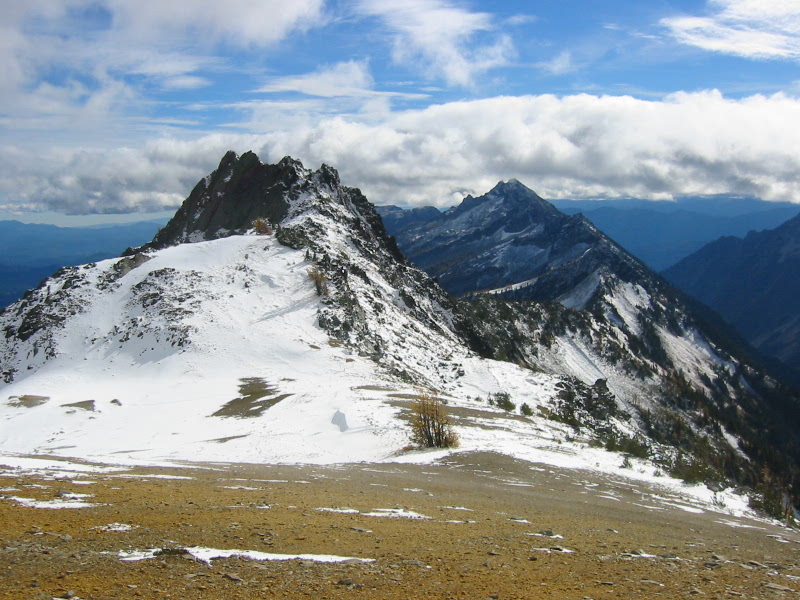 snowy mountain peaks in the Chiwawa Mountains with high clouds and gentle slope in the foreground