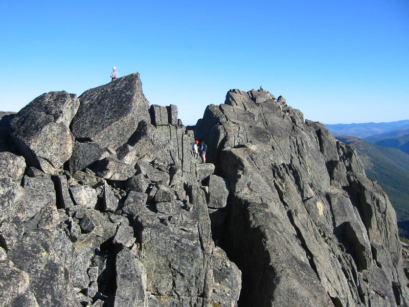 mountain climbers scrambling broken rock boulders on the summit of Cathedral Peak in the Similkameen Mountains in the Pasayten Wilderness