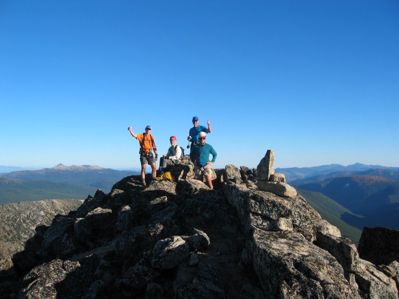 mountain climbers taking a break on the rock summit of Cathedral Peak in the Similkameen Mountains in the Pasayten Wilderness