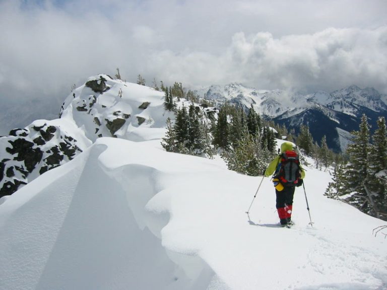 A snowshoer walks along a snowy ridge toward Frigid Mountain near Icicle Creek