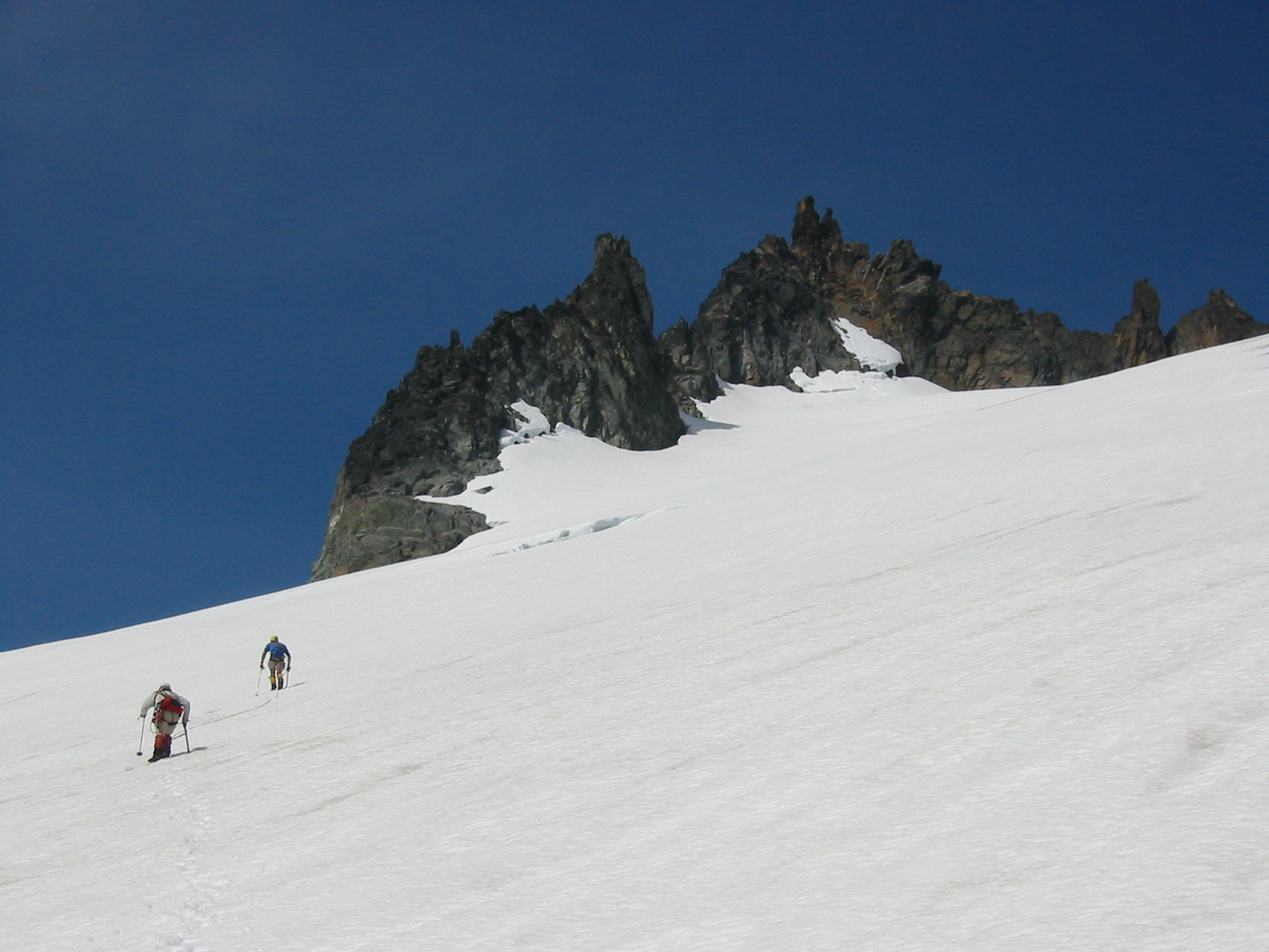 roped mountain climber scrambling rope approaching the summit of Spire Point in the Glacier Peak Wilderness
