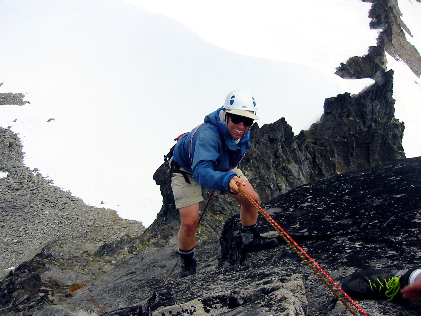 mountain climber rappelling off the summit of Spire Point in the Glacier Peak Wilderness