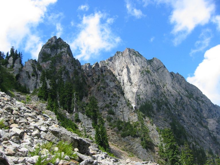 Sperry Peak towers over a green slope near Headlee Pass