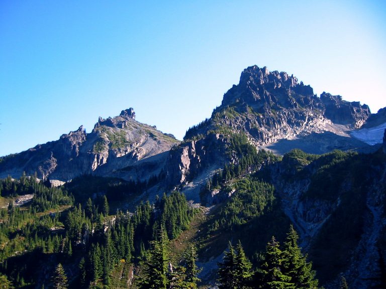 Two pointed peaks of Sluiskin Mountain stand above a forest slope