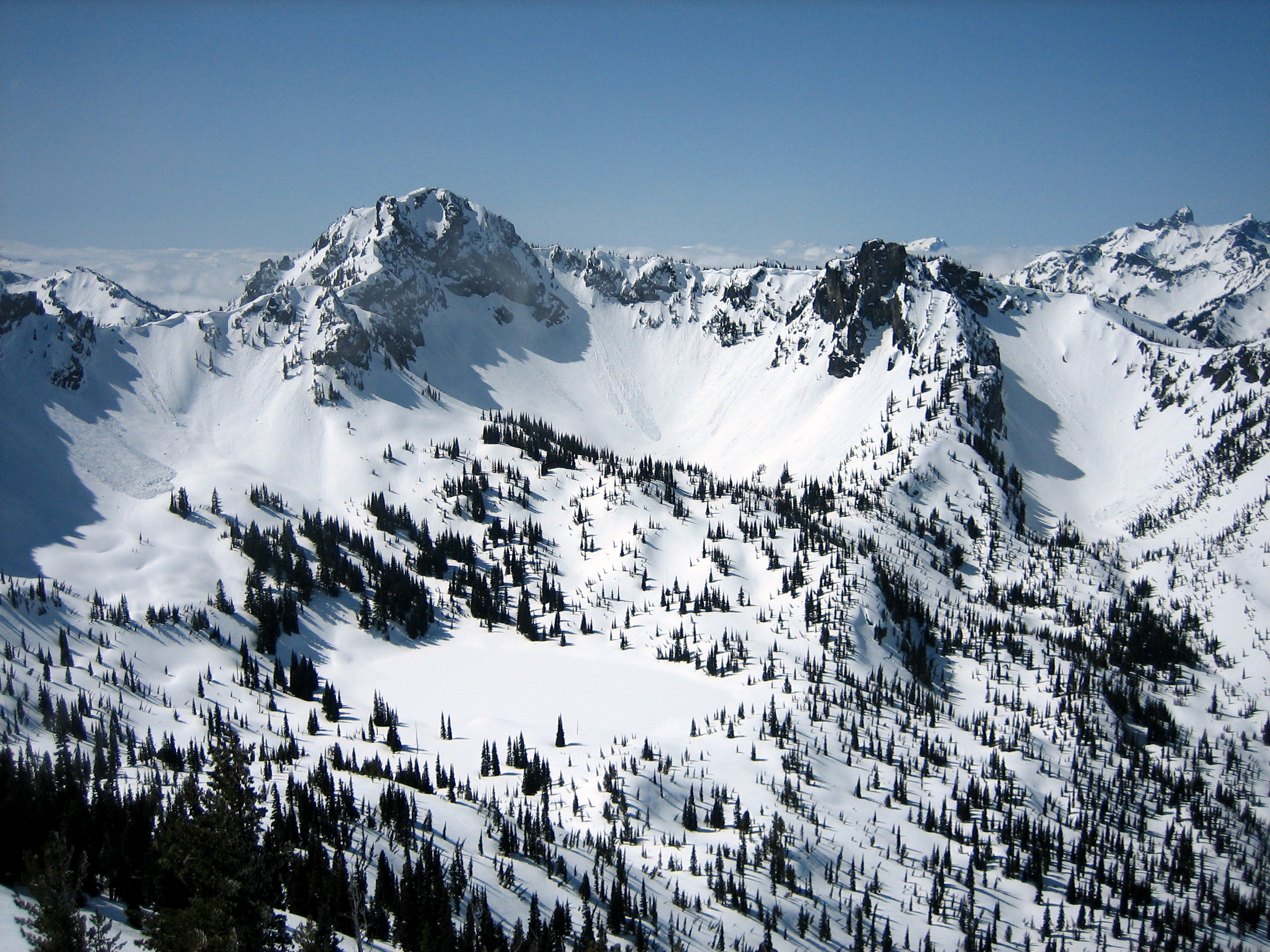 Chinook Peak stands above a snow-covered lake during the Chinook Peak Ski Circumnavigation