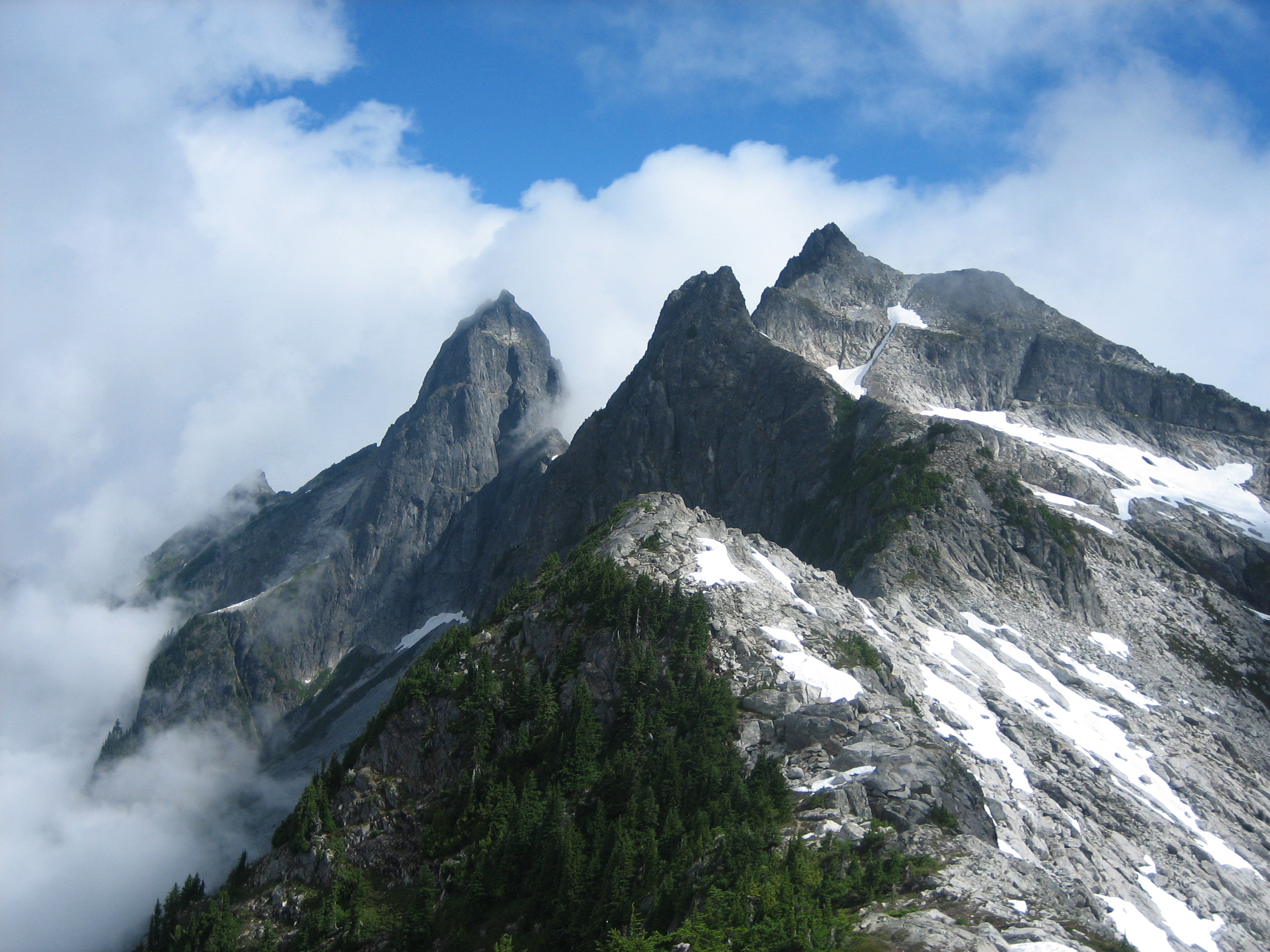 Fog swirling around Mt Triumph and two other rock horns in the Lower Skagit Mountains in North Cascades National Park