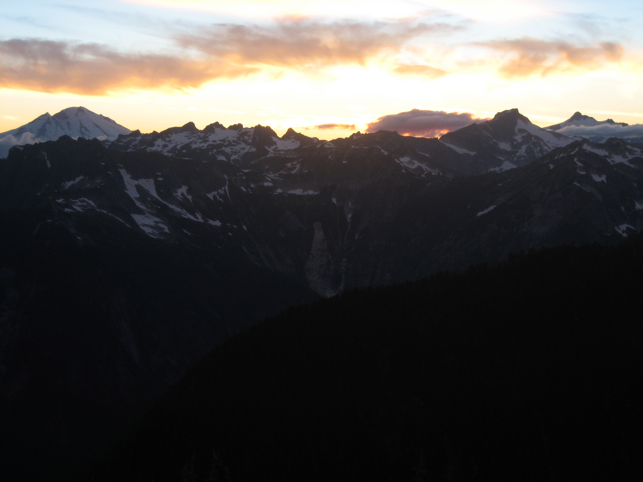 sunset on Mt Baker and Mt Shuksan as seen from mountain climber's camp on Thornton Pass in the Lower Skagit Mountains in North Cascades National Park