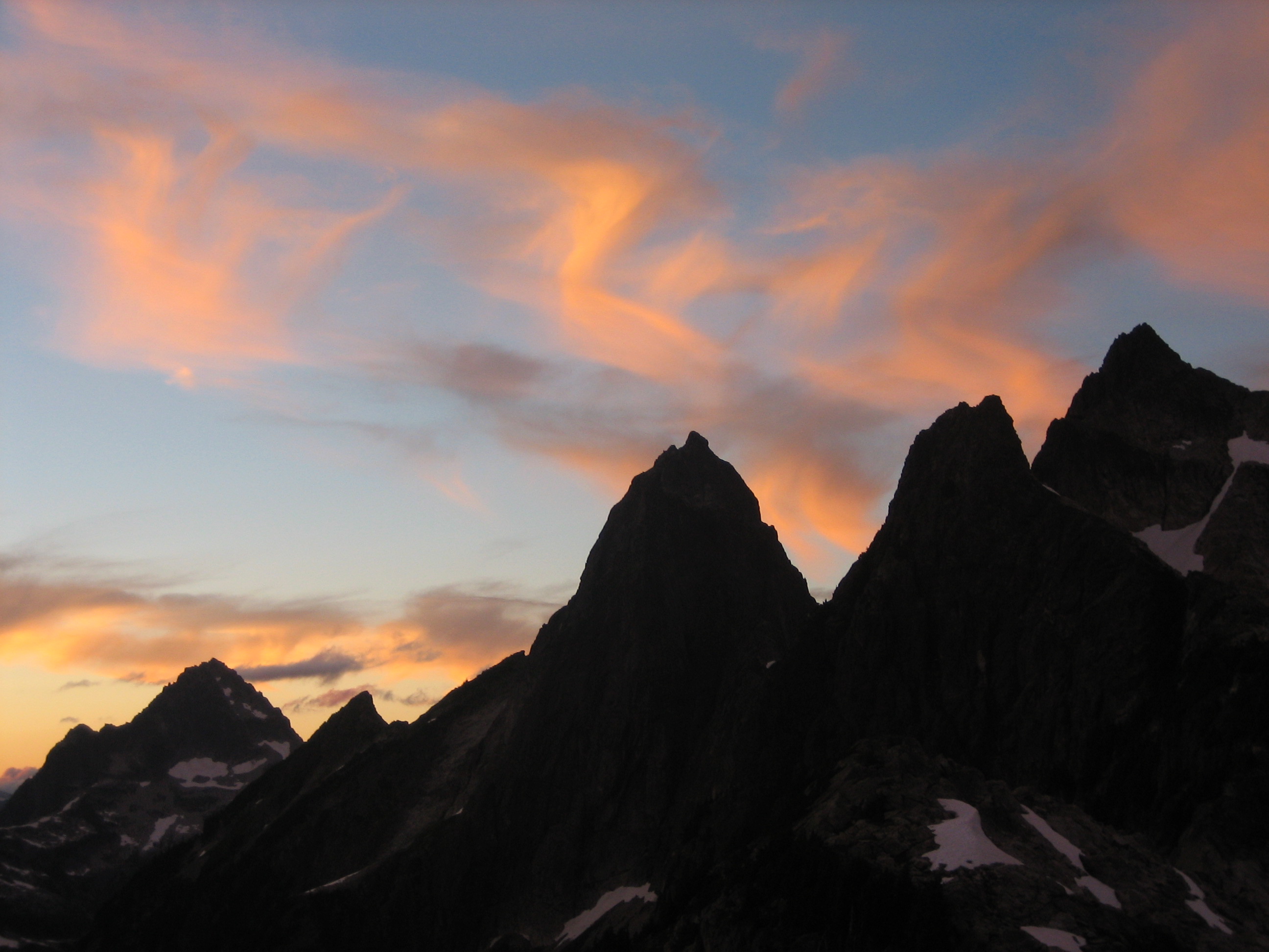 Sunset with swirling clouds over Mt Despair and Mt Triumph in the Lower Skagit Mountains in North Cascades National Park